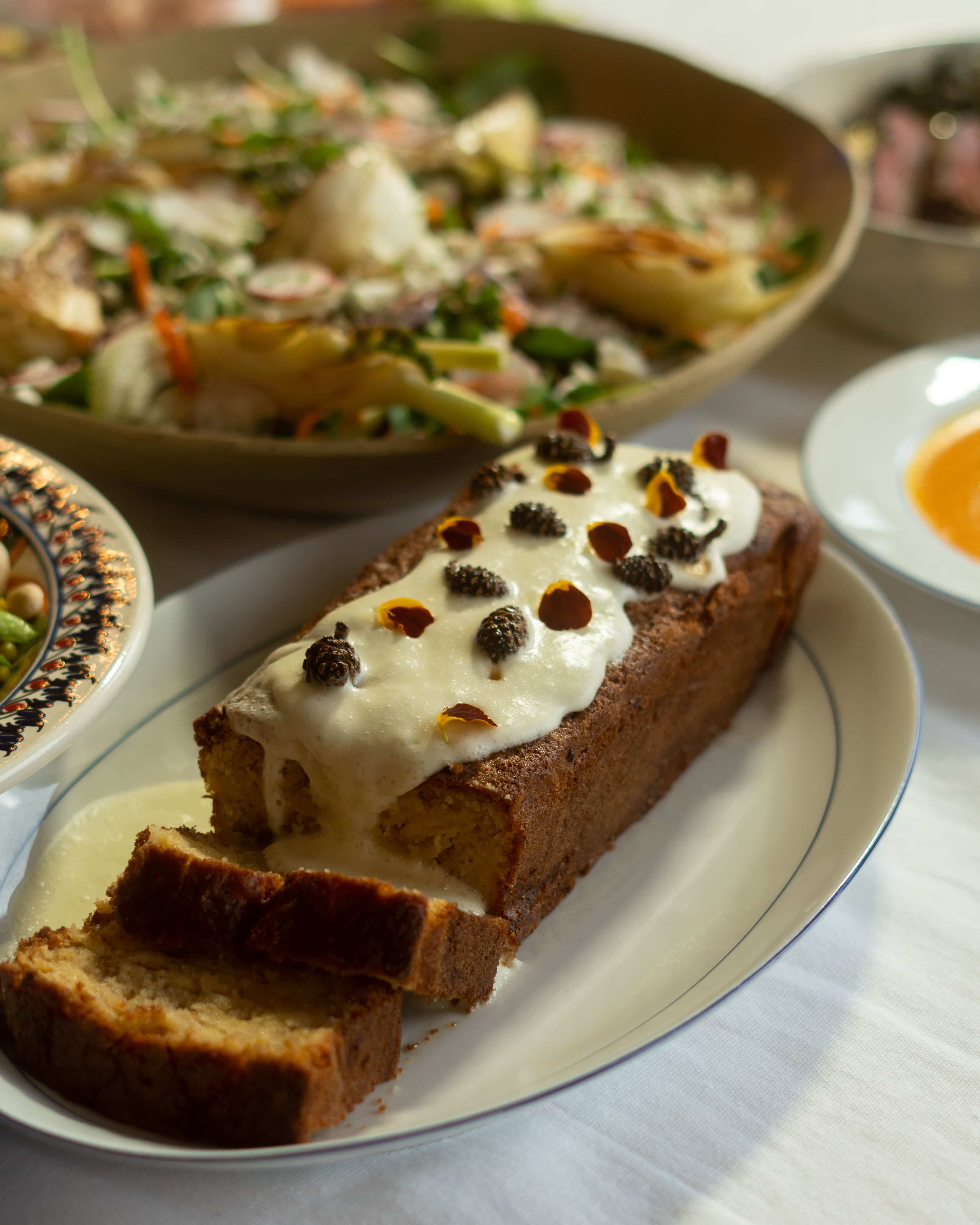 Bananenbrood met roomkaasglazuur en eetbare bloemen